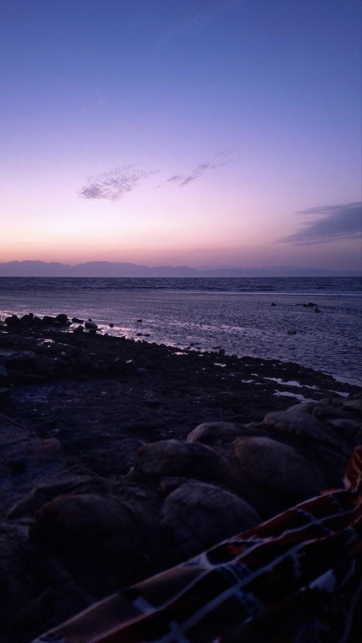 Sunset over the water from the rocky shore